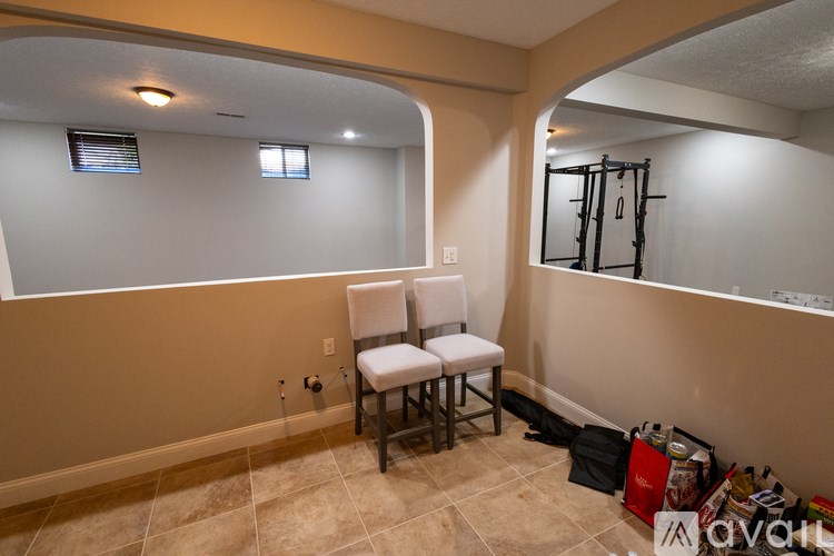 A room with a chair and a mirror on the wall.