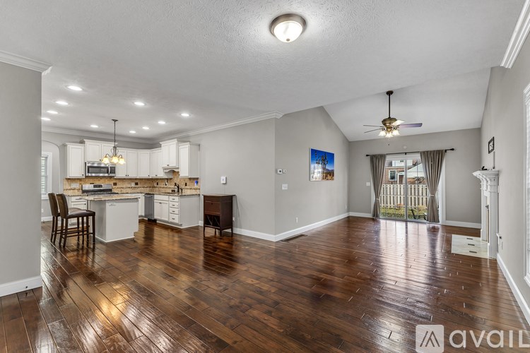 A kitchen with a granite countertop and a bicycle in the doorway.