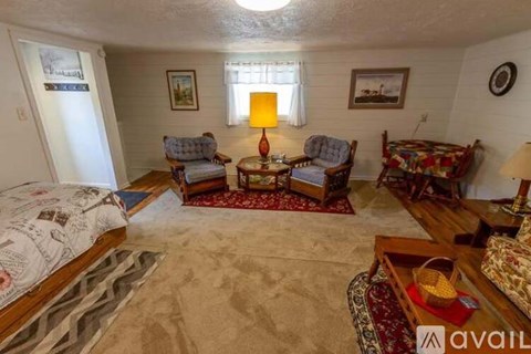 A living room with a sofa set, a bed, and a coffee table.