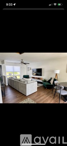 A living room with a white sofa and a ceiling fan.