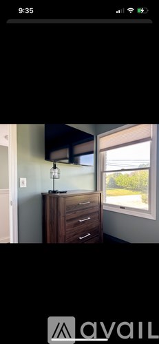 A wooden dresser with a flat screen TV mounted above it.