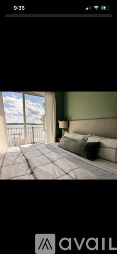 A bedroom with a large bed and a view of the sky through a window.