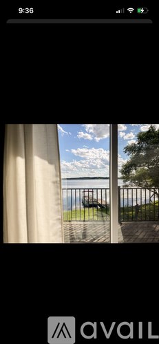 A view of a balcony with a railing and a body of water in the distance.