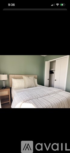 A bedroom with a bed, nightstand, and lamp.