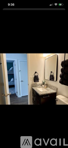 A bathroom with a sink, mirror, and towel rack.