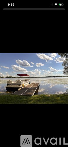 A boat is docked at a pier on a calm lake.