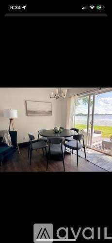 A dining room with a table set for four and a view of the outside.