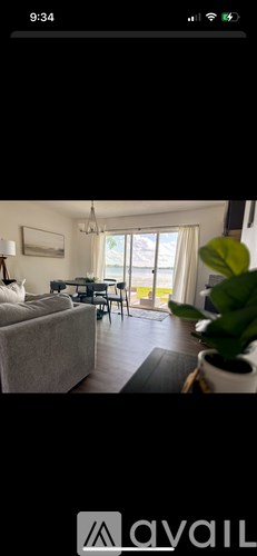 A living room with a couch, a table, and a potted plant.