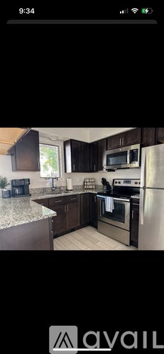 A kitchen with a stainless steel refrigerator and a microwave above the stove.