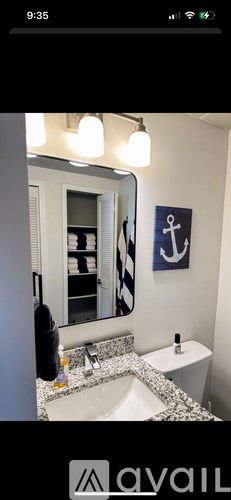 A bathroom with a sink, toilet and a mirror.