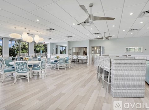 A spacious dining area with white chairs and tables.