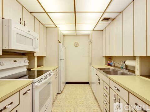 A kitchen with white cabinets and a white fridge.