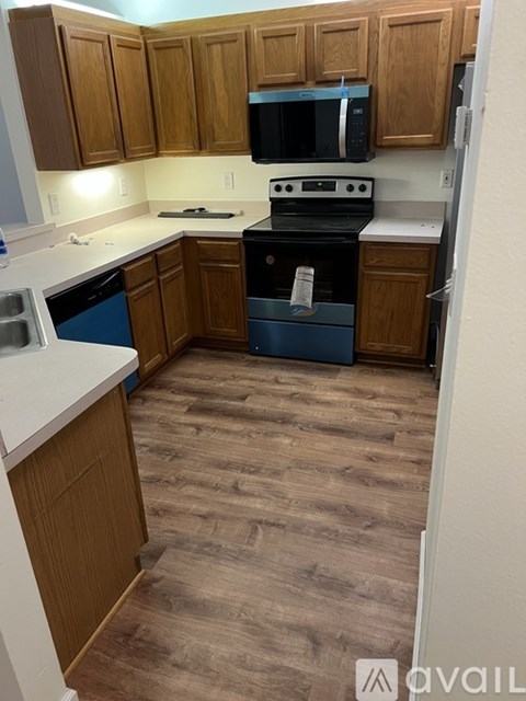 A kitchen with wooden cabinets and a blue dishwasher.