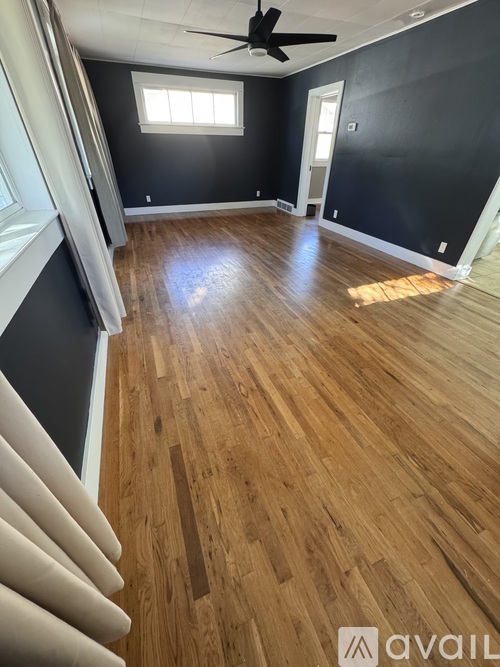 A room with wooden flooring and a ceiling fan.