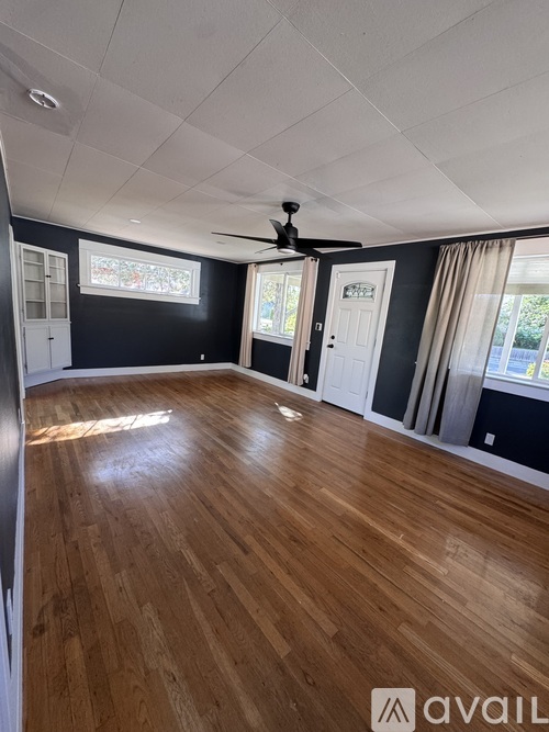 A room with wooden flooring and a ceiling fan.