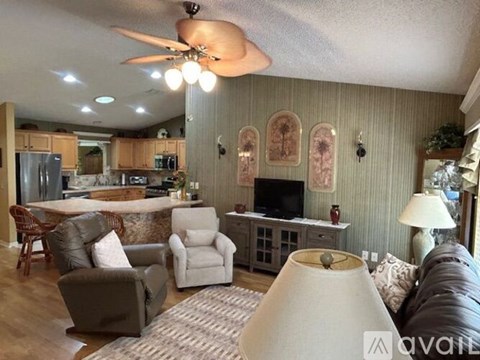 A living room with a brown couch and a white lamp.