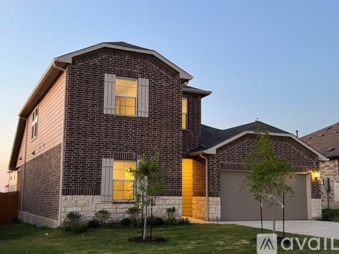 A house with a brown brick exterior and a garage door.
