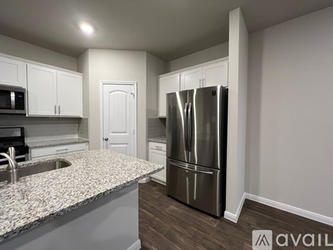 A kitchen with a granite countertop and stainless steel appliances.