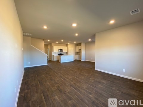 A spacious room with wooden flooring and a white reception desk.
