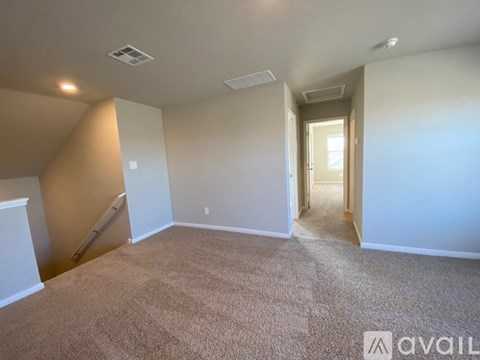 A room with beige carpet and white walls is available for rent.