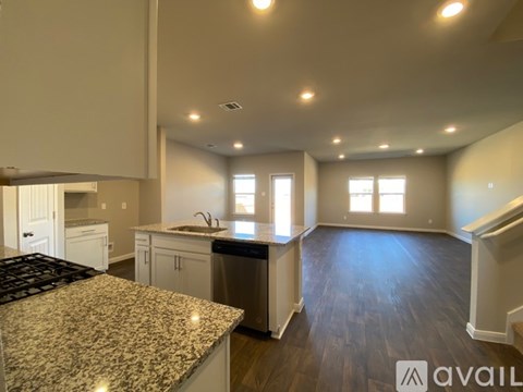 A kitchen with granite countertops and wood flooring.
