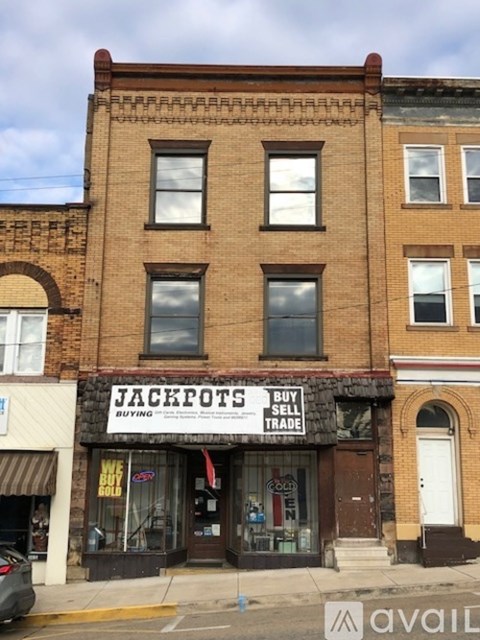 A brick building with a storefront that says "Jackpots Buy Sell Trade".