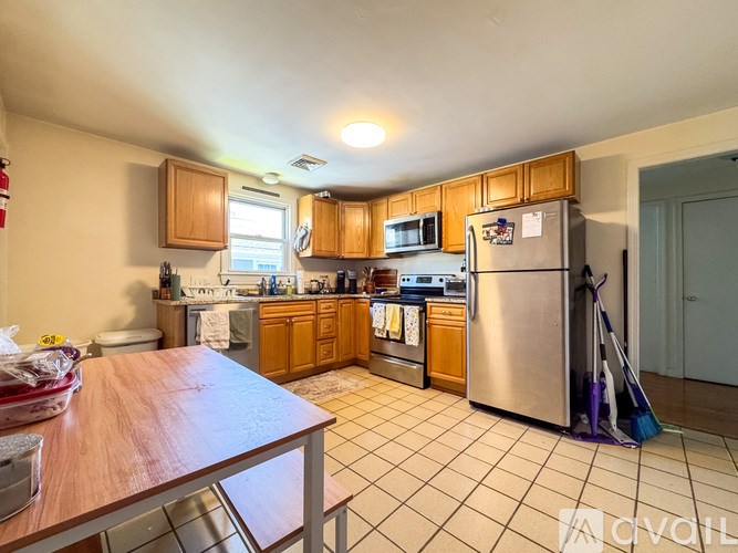 A kitchen with a refrigerator, sink, and cabinets.