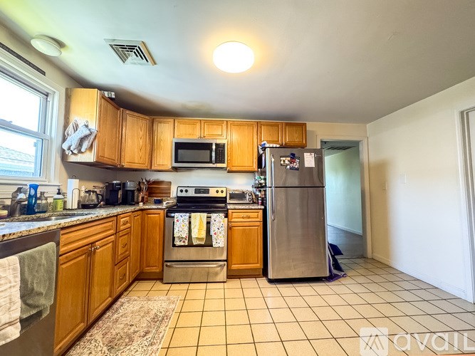 A kitchen with wooden cabinets and a stainless steel refrigerator.