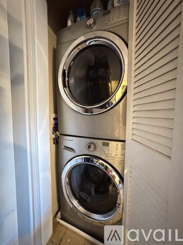 A stacked washer and dryer in a small room.