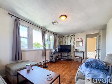 A living room with a grey couch and a wooden coffee table.