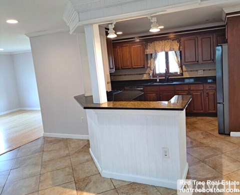 A kitchen with a white island in the middle.