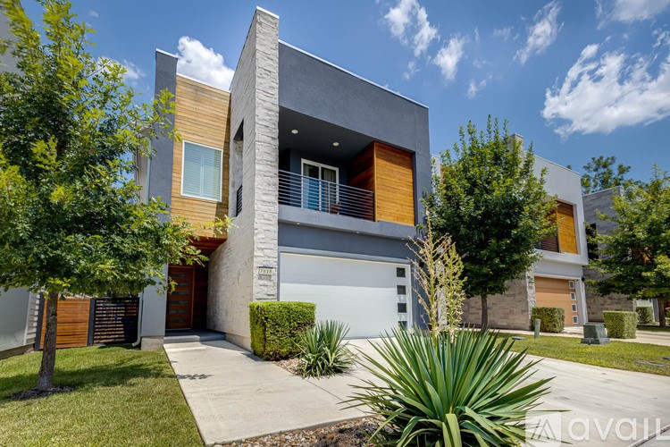 A modern house with a grey and brown exterior and a white garage door.