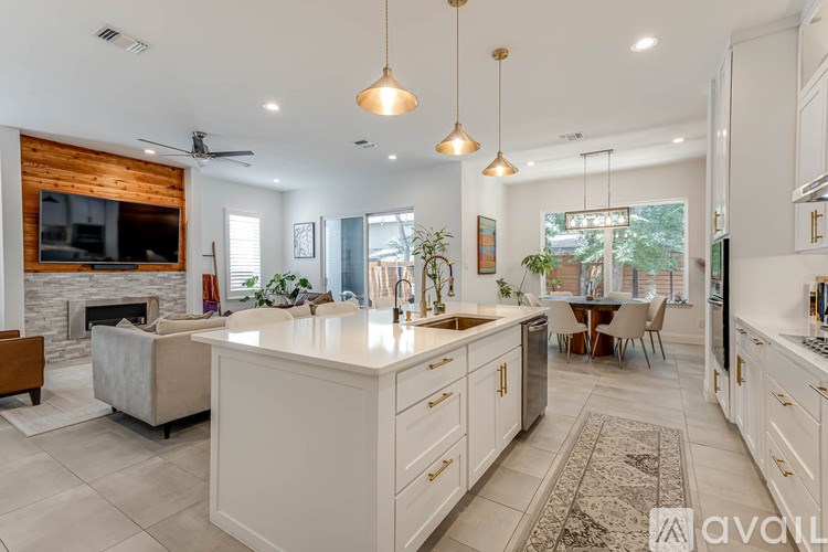 A modern kitchen with a large island and pendant lights.