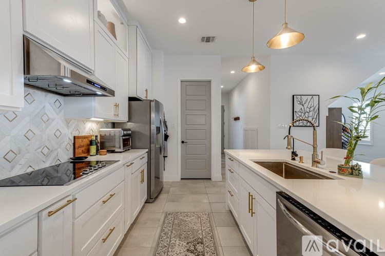 A kitchen with white cabinets and a patterned backsplash.