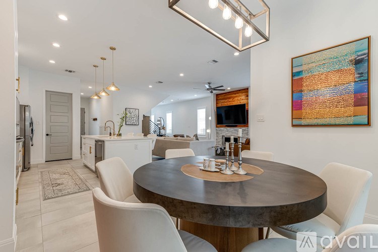 A modern dining room with a round table and chairs.