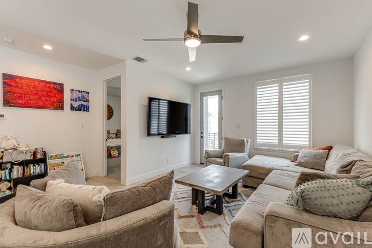 A living room with a couch, a chair, a coffee table, and a television.