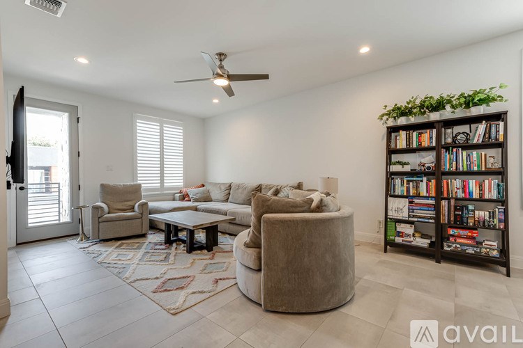 A living room with a couch, a chair, a coffee table, and a bookshelf.
