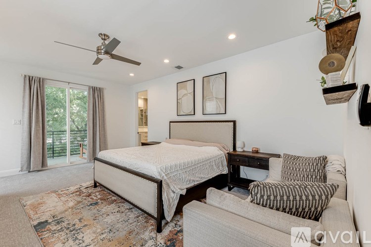 A bedroom with a large bed and a ceiling fan.