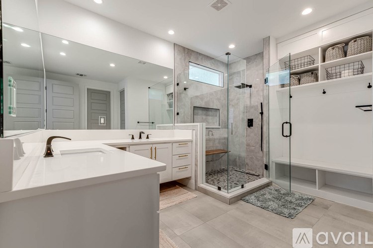 A modern bathroom with a walk-in shower and double sink vanity.
