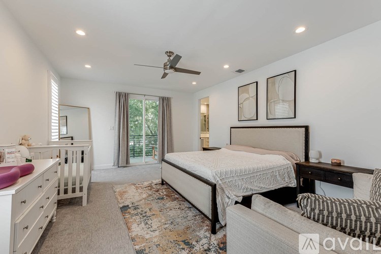 A bedroom with a bed, dresser, and couch.