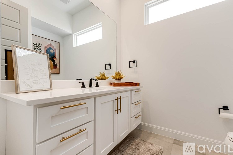 A bathroom with a white countertop and cabinets.