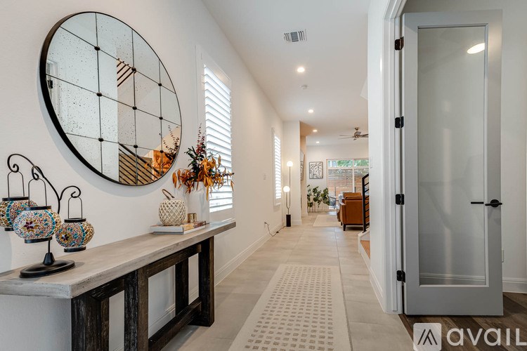 A hallway with a round mirror on the wall and a door on the right.
