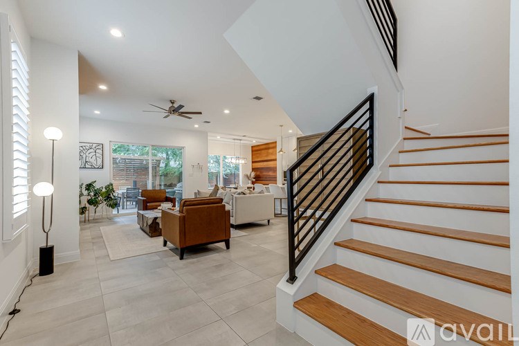 A spacious living room with a staircase leading to the upper floor.