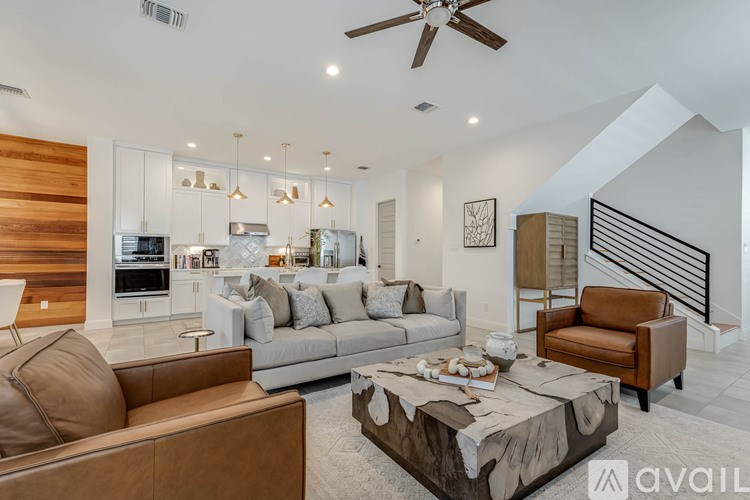 A modern living room with a brown leather couch and a coffee table.