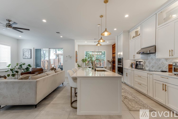 A modern kitchen with a dining area and a living room area.