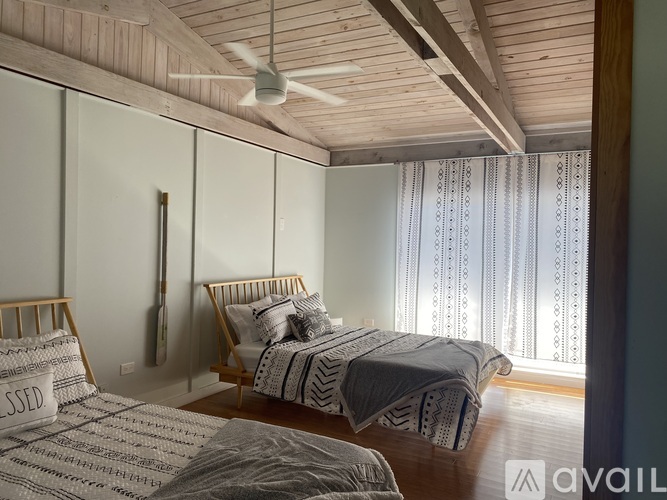 A bedroom with two beds and a ceiling fan.