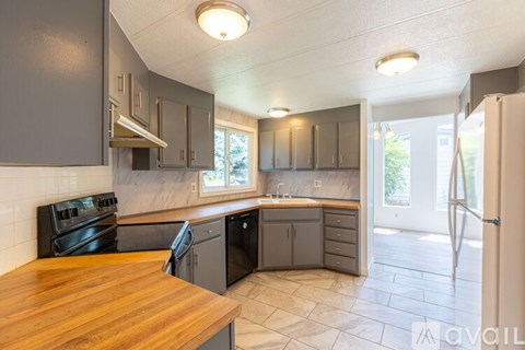 A kitchen with a wooden counter top and stainless steel appliances.