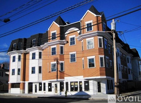 A large two-story building with a red brick facade and white trim.