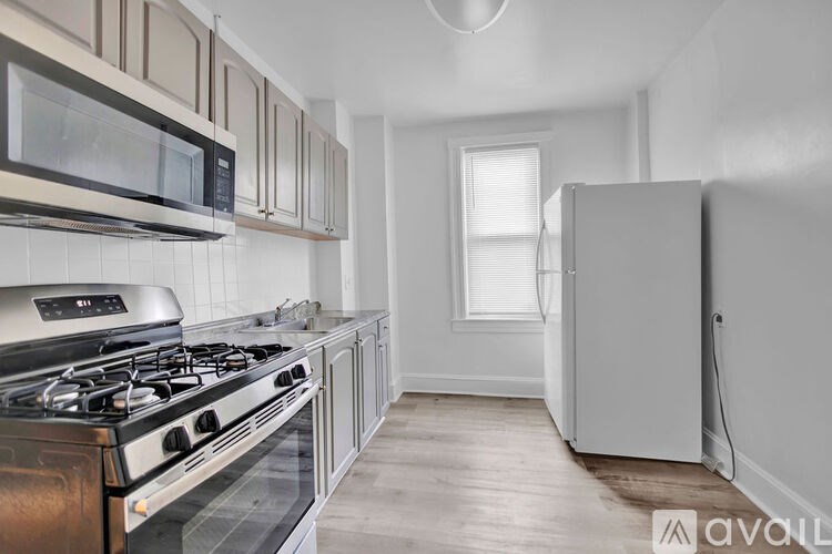 A kitchen with a stove, microwave, and refrigerator.