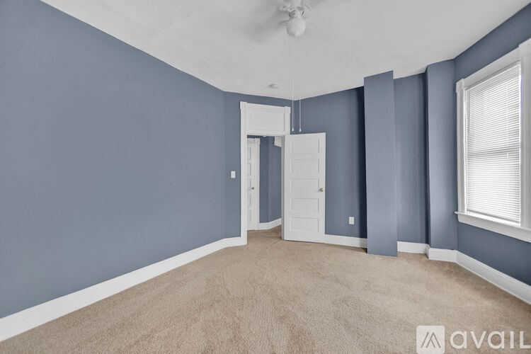 A room with a ceiling fan and a door.